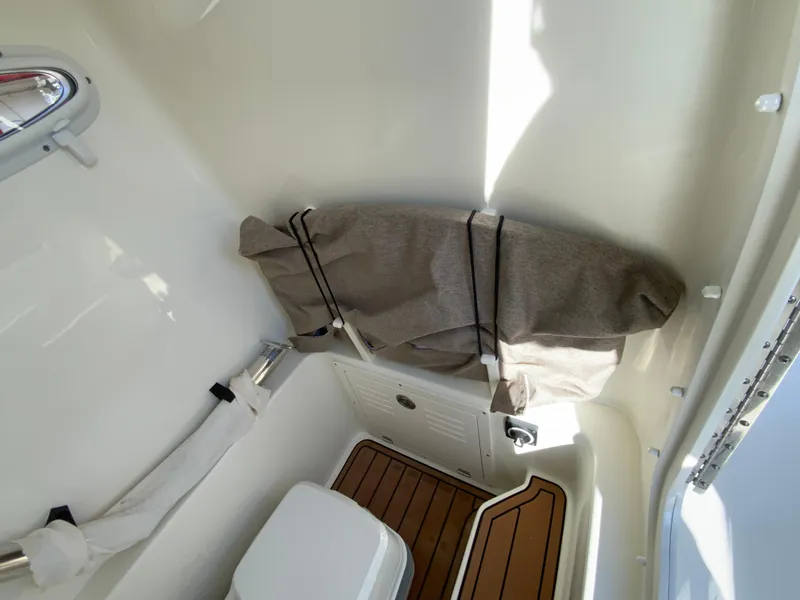Slide: The Image of 2025 Pathfinder 2400 TRS boat interior with storage and seating area. - 34