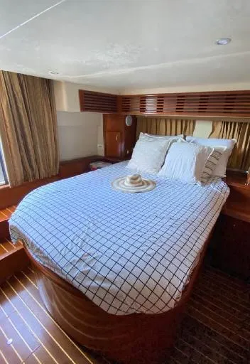 Slide: The Image of Interior of 2004 Carver 444 Cockpit Motor Yacht with cozy bed and wooden accents. - 3
