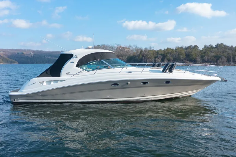 Slide: The Image of 2005 Sea Ray 420 Sundancer yacht on a serene lake with clear skies. - 0