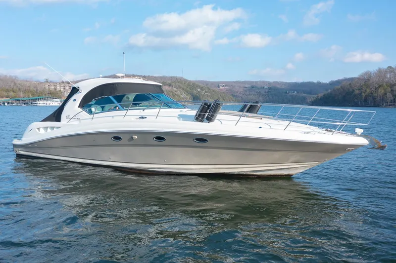 Slide: The Image of 2005 Sea Ray 420 Sundancer yacht on a serene lake under a blue sky. - 1
