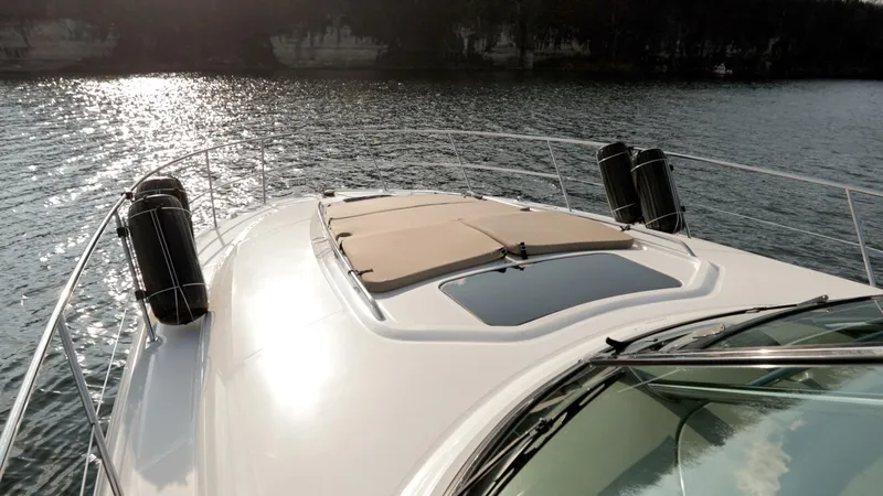 Slide: The Image of 2005 Sea Ray 420 Sundancer yacht on calm water, sun reflecting on deck. - 14