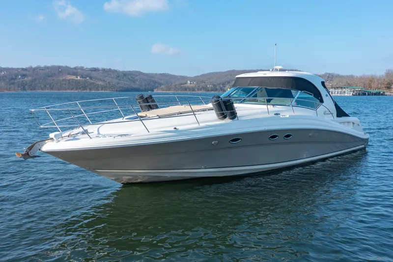 Slide: The Image of 2005 Sea Ray 420 Sundancer yacht cruising on a serene lake. - 2