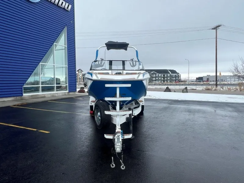 Slide: The Image of 2019 Nautique G25 boat on trailer, parked outside a blue building. - 10