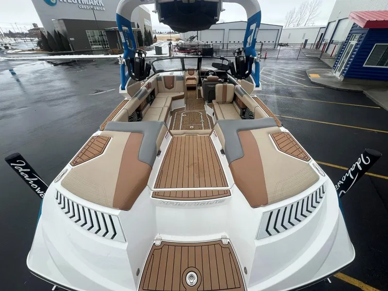 Slide: The Image of 2019 Nautique G25 boat with spacious seating and sleek design in a parking lot. - 11