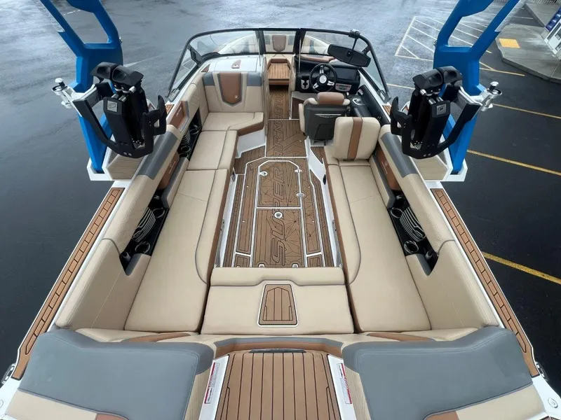 Slide: The Image of 2019 Nautique G25 boat interior with beige seating and wood accents. - 12