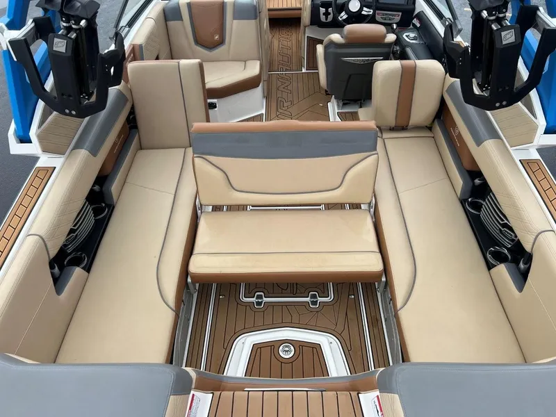 Slide: The Image of 2019 Nautique G25 boat interior with beige and brown seating, featuring a modern design. - 13