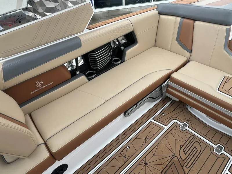 Slide: The Image of 2019 Nautique G25 interior with beige and brown seating, stylish design, and cup holders. - 18