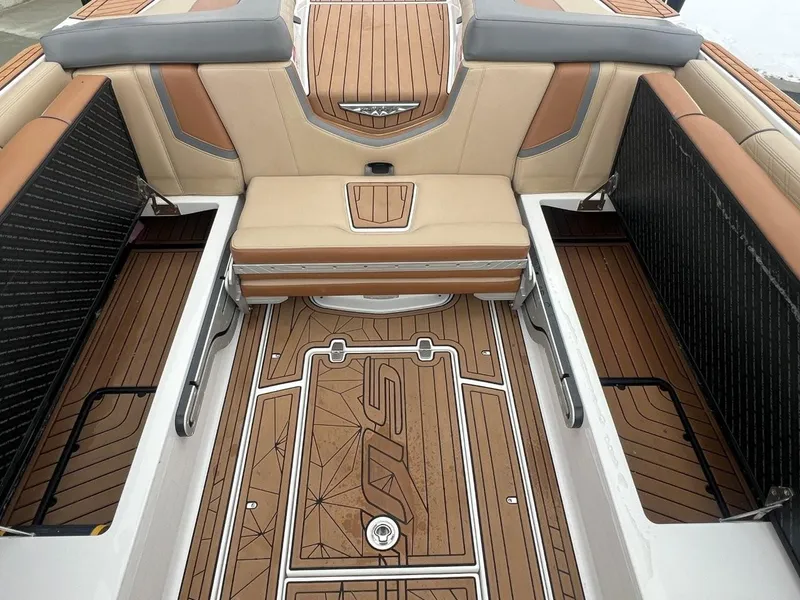 Slide: The Image of 2019 Nautique G25 boat interior with tan and brown seating and flooring. - 19