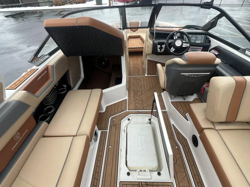 Slide: The Image of 2019 Nautique G25 boat interior with tan seating and modern dashboard design. - 20