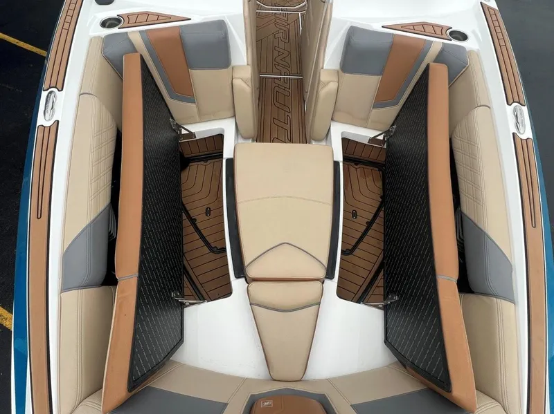 Slide: The Image of 2019 Nautique G25 boat interior with tan and gray seating, showcasing luxury design. - 23