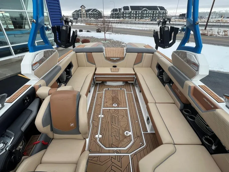 Slide: The Image of 2019 Nautique G25 boat interior with tan and brown seating, blue accents, and modern design. - 24