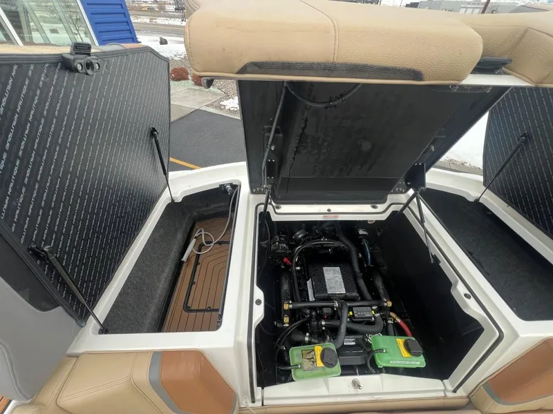 Slide: The Image of 2019 Nautique G25 engine compartment with open hatches, showcasing detailed interior components. - 25