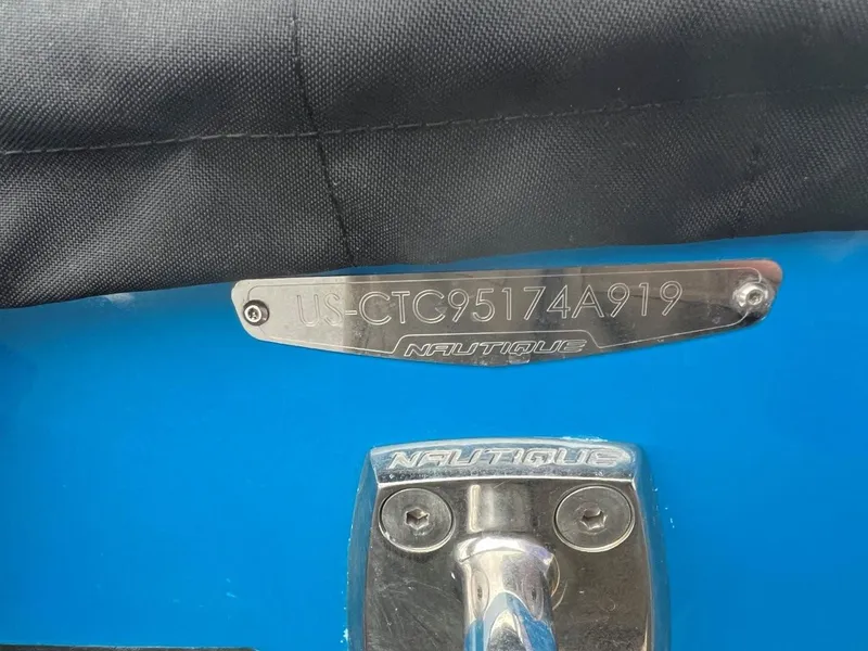 Slide: The Image of 2019 Nautique G25 boat identification plate and logo on blue surface. - 27