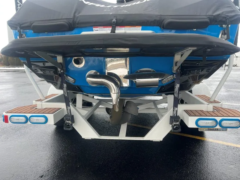 Slide: The Image of 2019 Nautique G25 boat rear view with trailer, showcasing propeller and exhaust system. - 6