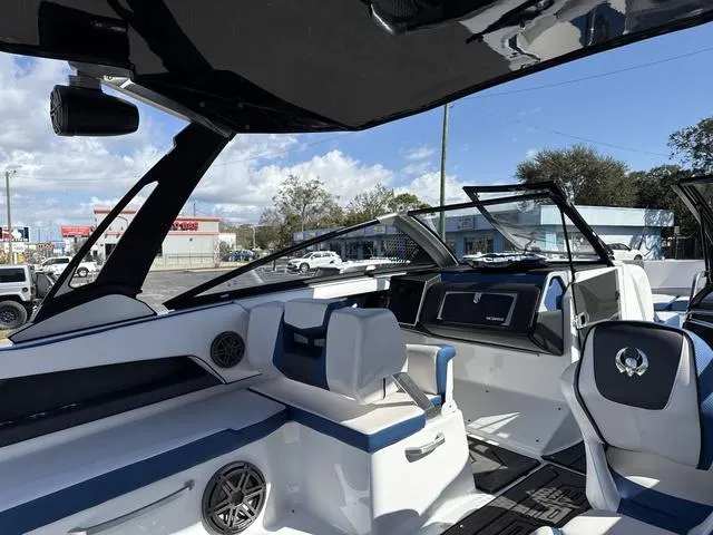 Slide: The Image of 2024 Scarab SBI285 boat interior with modern seating and dashboard, featuring blue and white accents. - 13