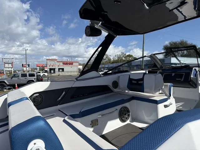 Slide: The Image of 2024 Scarab SBI285 boat interior with blue and white seating, speakers, and modern design. - 14