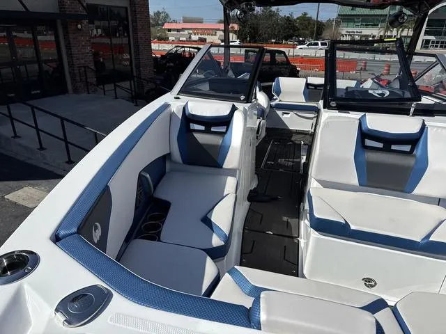 Slide: The Image of 2024 Scarab SBI285 boat interior with blue and white seating, cup holders, and modern design. - 15