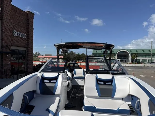 Slide: The Image of 2024 Scarab SBI285 boat with sleek interior, parked near a service building under a clear sky. - 17