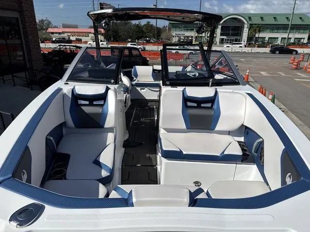 Slide: The Image of 2024 Scarab SBI285 boat interior with white and blue seating, docked in a marina. - 20