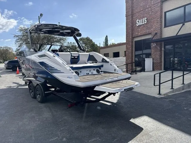 Slide: The Image of 2024 Scarab SBI285 boat on trailer outside sales building, sunny day. - 3