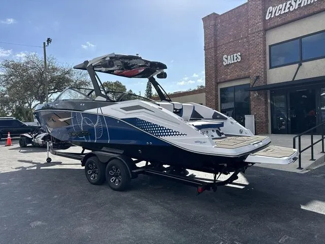 Slide: The Image of 2024 Scarab SBI285 boat on trailer outside sales building, showcasing sleek design. - 4