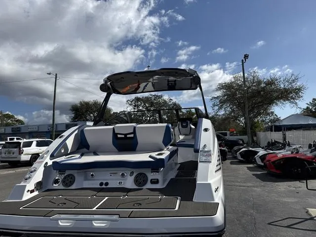 Slide: The Image of 2024 Scarab SBI285 boat with sleek design and spacious seating under a cloudy sky. - 6