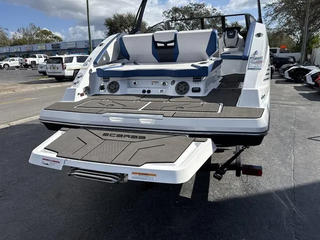 Slide: The Image of 2024 Scarab SBI285 boat with spacious deck and seating, parked outdoors. - 7