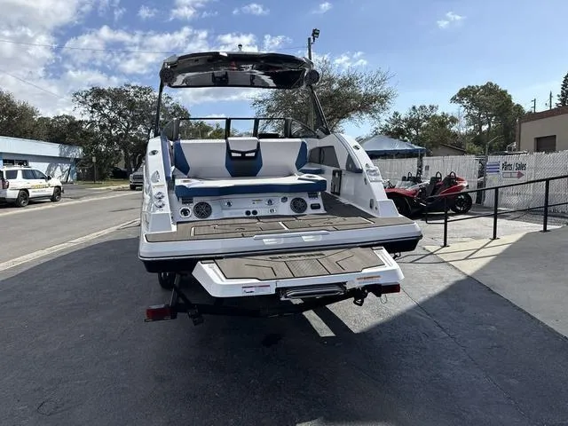 Slide: The Image of 2024 Scarab SBI285 boat, rear view, parked outdoors on a sunny day. - 8