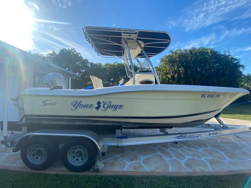 Slide: The Image of 2005 Scout 210 Sportfish boat on trailer, sunny day, palm trees in background. - 10