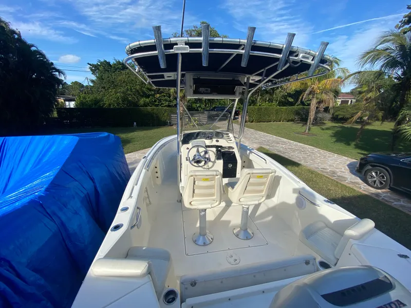 Slide: The Image of 2005 Scout 210 Sportfish boat with T-top and dual seats, parked outdoors. - 15