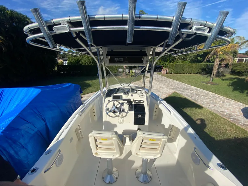 Slide: The Image of 2005 Scout 210 Sportfish boat with dual seats and T-top in a sunny yard. - 18