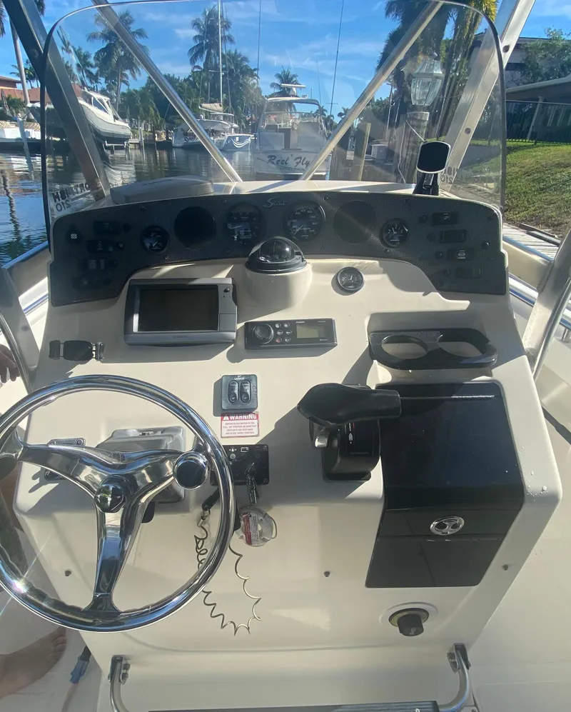 Slide: The Image of 2005 Scout 210 Sportfish boat dashboard with steering wheel and controls. - 24