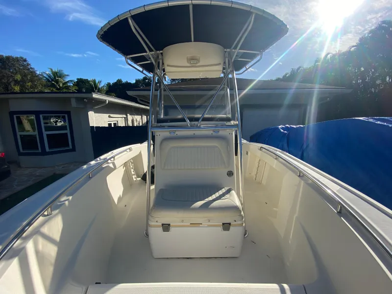 Slide: The Image of 2005 Scout 210 Sportfish boat with T-top, parked in driveway under sunny sky. - 28