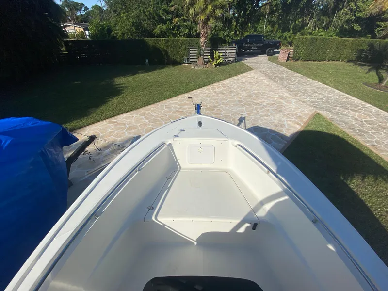 Slide: The Image of 2005 Scout 210 Sportfish boat parked on a stone driveway, surrounded by greenery. - 29