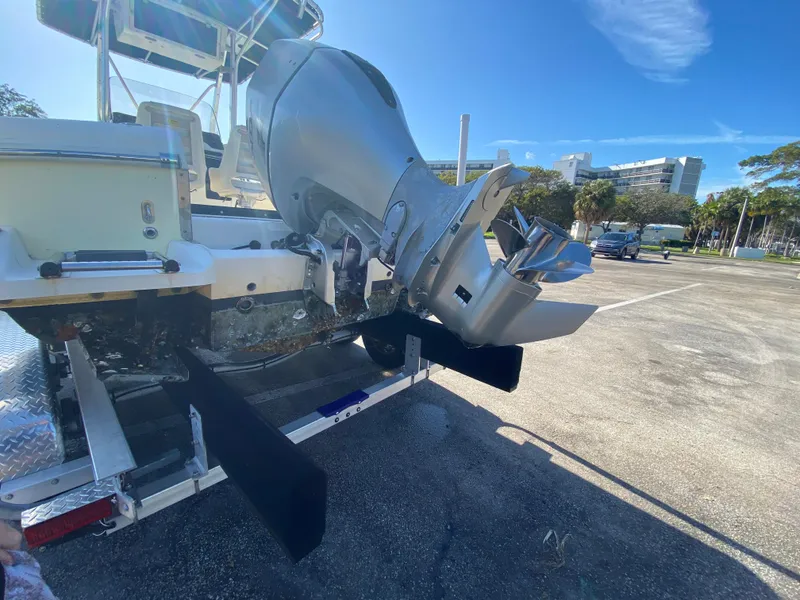 Slide: The Image of 2005 Scout 210 Sportfish boat on trailer, showing outboard motor in parking lot. - 6