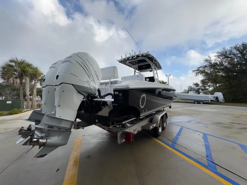 Slide: The Image of 2018 Fountain 34 CC boat on trailer with dual engines, parked outdoors. - 15