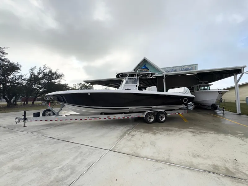 Slide: The Image of 2018 Fountain 34 CC boat on trailer at marina, overcast sky. - 2
