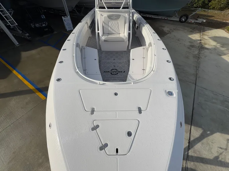Slide: The Image of 2018 Fountain 34 CC boat, top view, white deck, parked on concrete. - 20