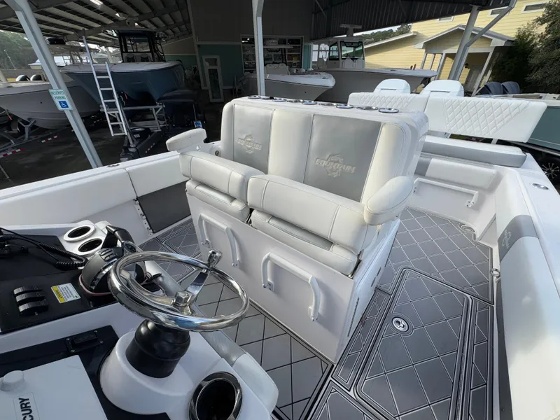 Slide: The Image of 2018 Fountain 34 CC boat interior with steering wheel and cushioned seating. - 27
