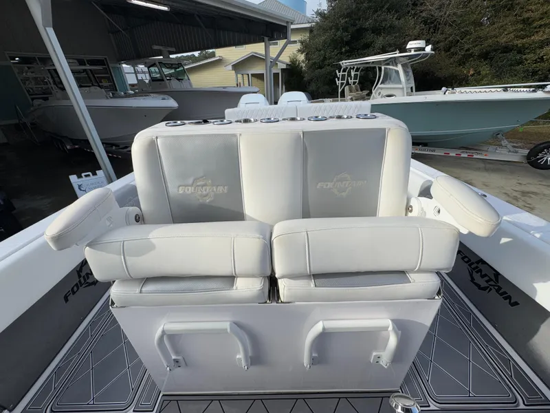 Slide: The Image of 2018 Fountain 34 CC boat with cushioned seating and storage, docked outdoors. - 28