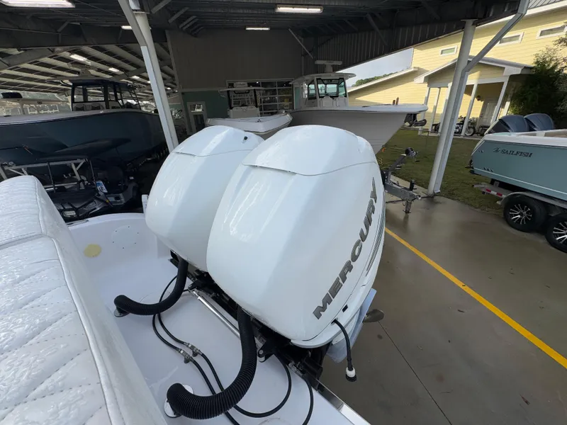 Slide: The Image of 2018 Fountain 34 CC boat with dual Mercury outboard engines in a covered marina. - 38