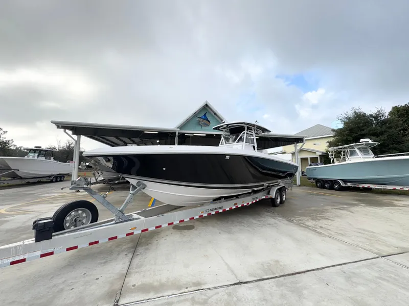 Slide: The Image of 2018 Fountain 34 CC boat on trailer, parked outdoors under cloudy sky. - 4