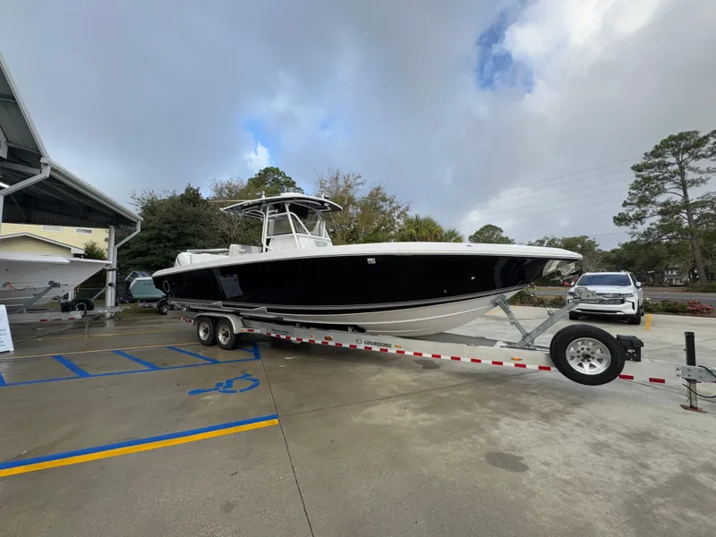 Slide: The Image of 2018 Fountain 34 CC boat on trailer in parking lot, overcast sky. - 9