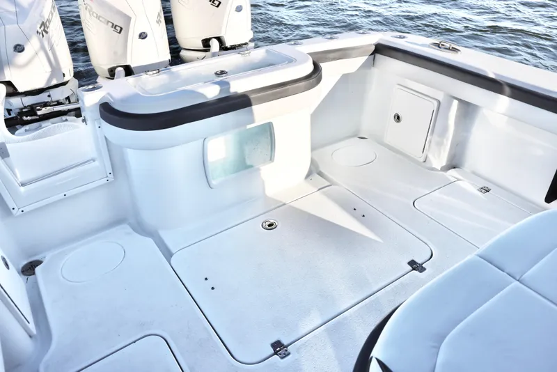 Slide: The Image of 2023 Yellowfin 36 Offshore boat deck with storage and seating, near water. - 8