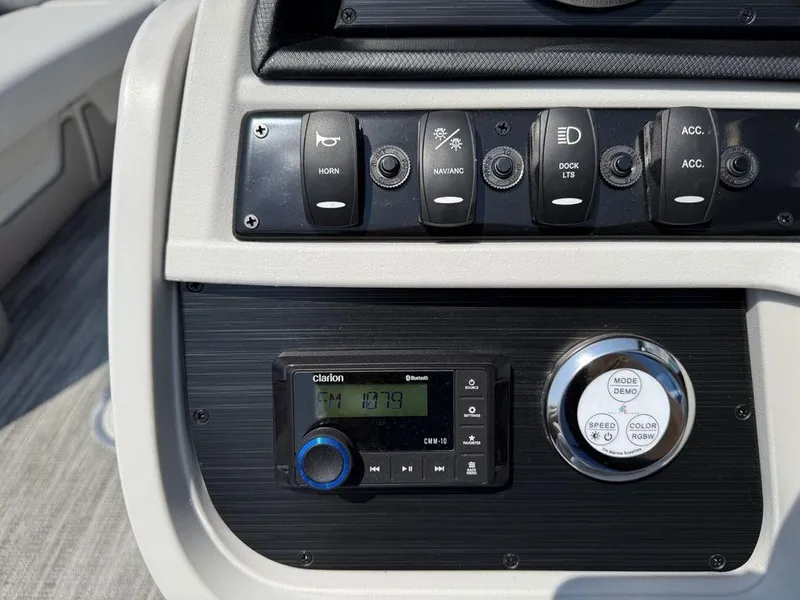 Slide: The Image of Control panel of 2025 Godfrey Sweetwater 2486 DT boat with switches and Clarion audio system. - 13