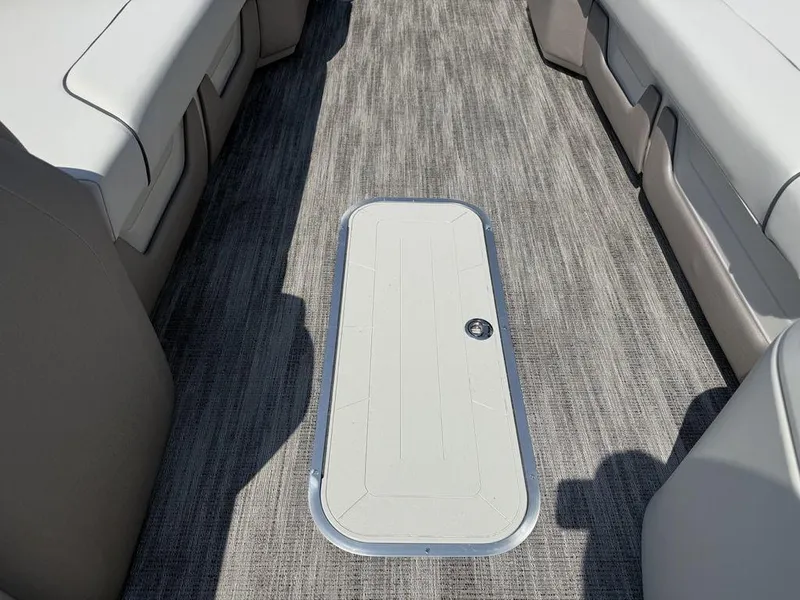 Slide: The Image of 2025 Godfrey Sweetwater 2486 DT boat interior with gray flooring and white seating. - 17