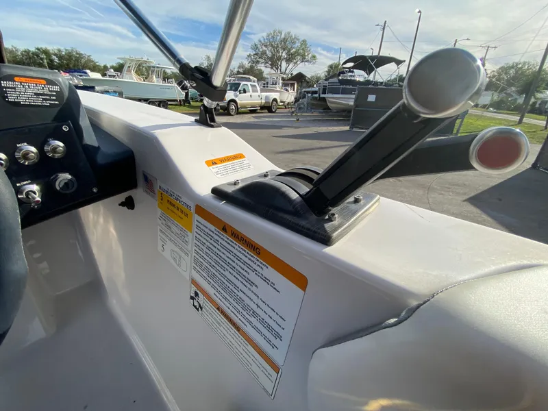Slide: The Image of 2018 Scarab 165 G boat controls and dashboard in a marina setting. - 13