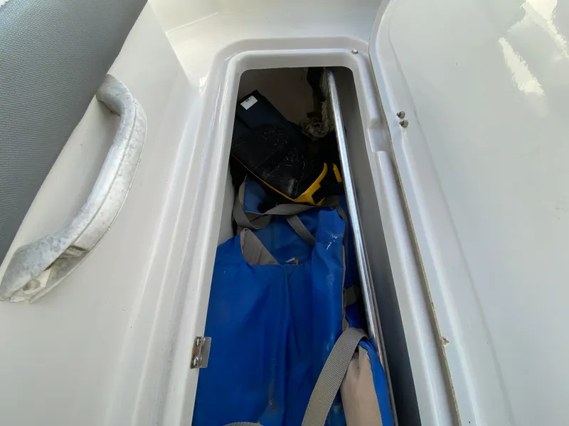 Slide: The Image of Storage compartment in 2018 Scarab 165 G boat with blue bag and equipment. - 21