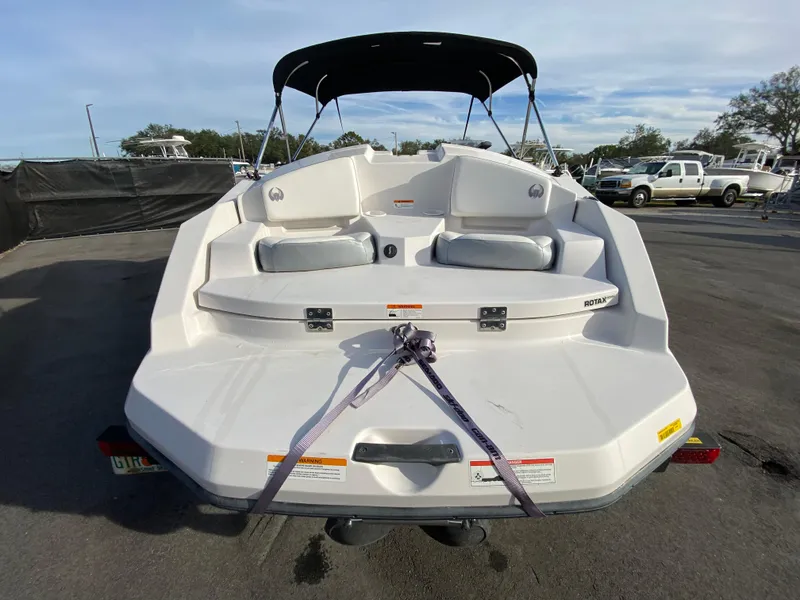 Slide: The Image of 2018 Scarab 165 G boat, rear view with seating and canopy, parked outdoors. - 3
