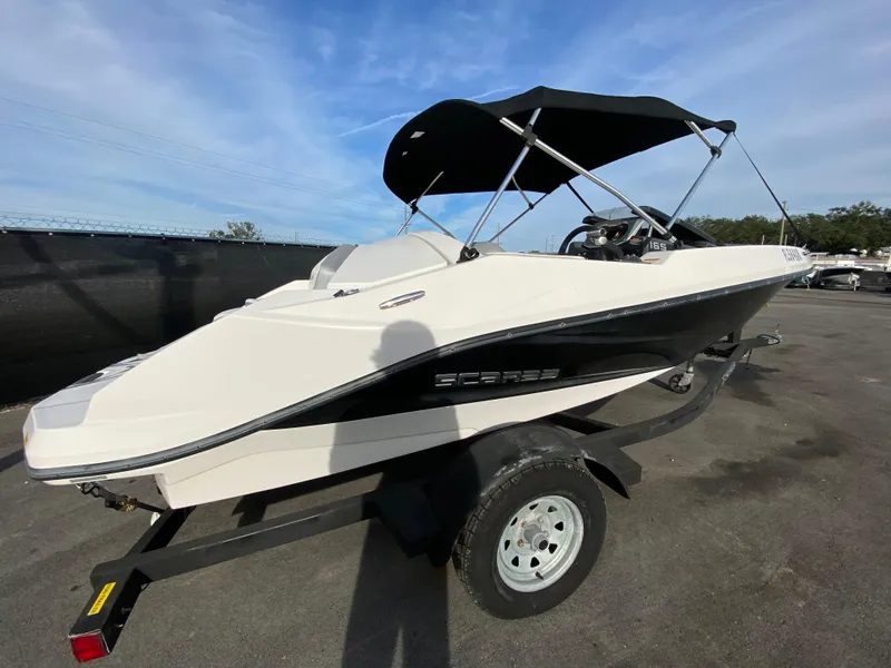 Slide: The Image of 2018 Scarab 165 G boat with canopy on trailer, parked outdoors. - 4